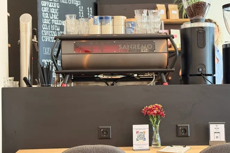 Café counter at KOKO Coffee Lab with San Remo portafilter machine, coffee menu on chalkboard and professional grinder