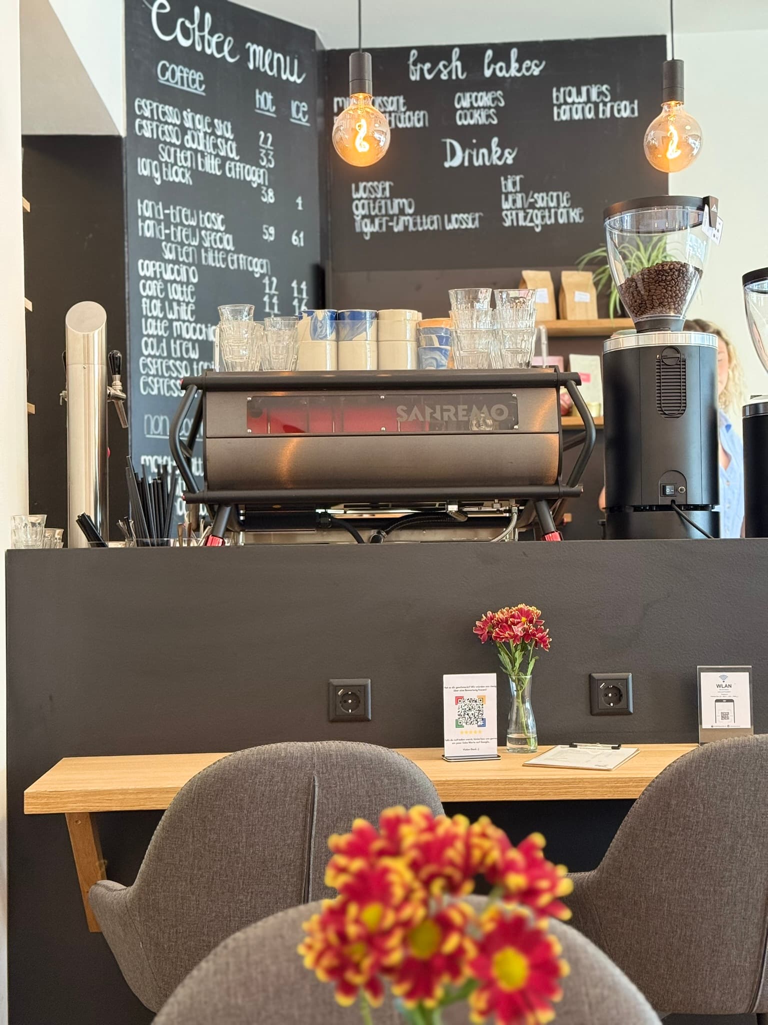 Café counter at KOKO Coffee Lab with San Remo portafilter machine, coffee menu on chalkboard and professional grinder