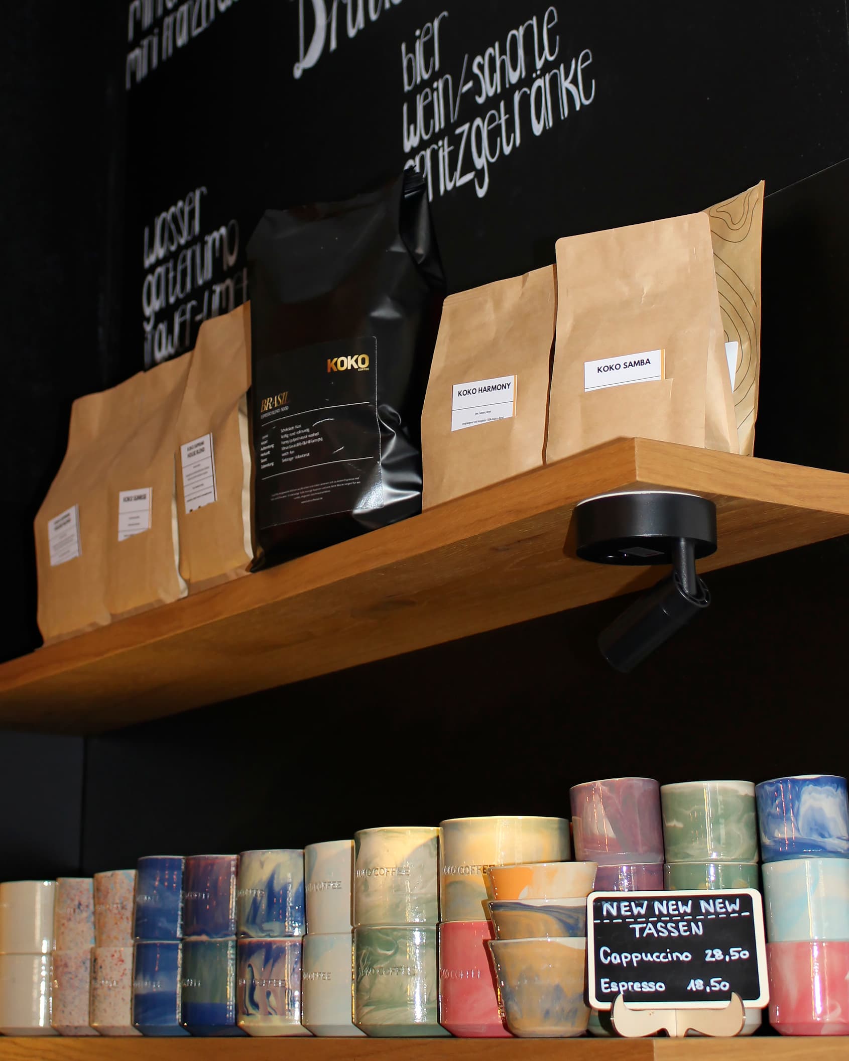 Shop shelf with KOKO Brasil, Harmony and Samba bean bags and colorful row of ceramic cups below