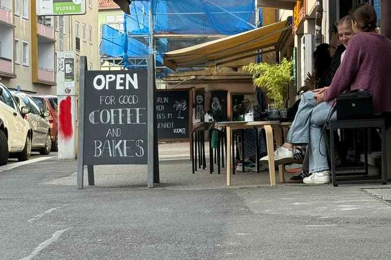 Außenansicht des KOKO Coffee Lab in der Münzstraße Würzburg mit Open-for-Good-Coffee-Schild und Außentischen